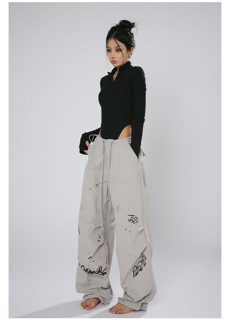 AN JITT's graffiti print work pants for women in spring and summer feature a jazz-inspired new American style with loose black dance pants.