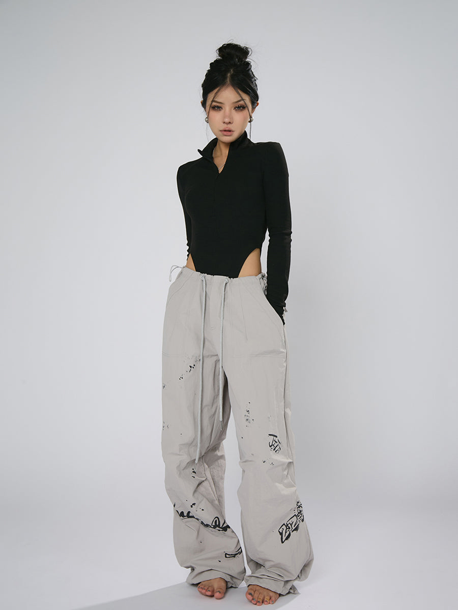 AN JITT's graffiti print work pants for women in spring and summer feature a jazz-inspired new American style with loose black dance pants.