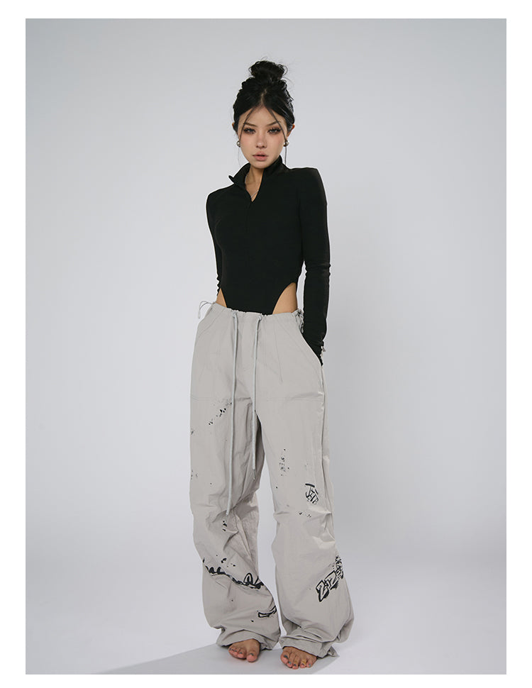 AN JITT's graffiti print work pants for women in spring and summer feature a jazz-inspired new American style with loose black dance pants.