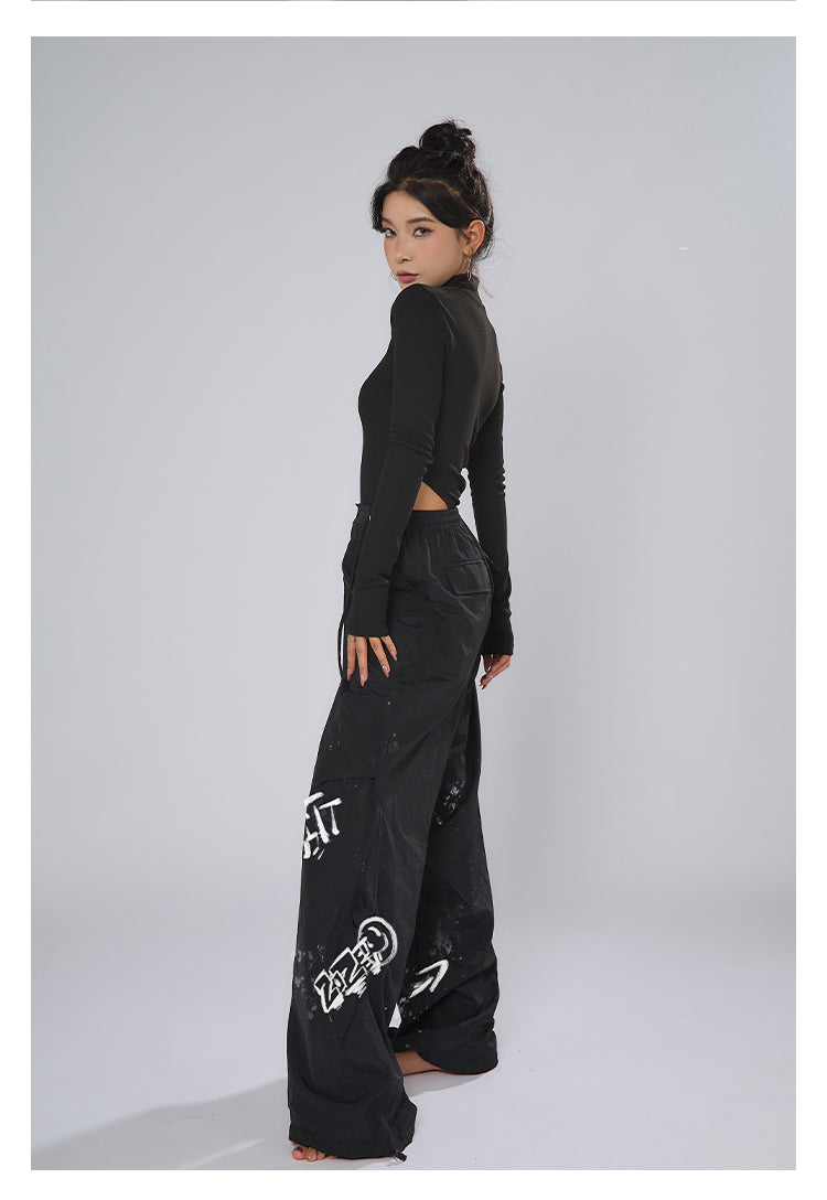 AN JITT's graffiti print work pants for women in spring and summer feature a jazz-inspired new American style with loose black dance pants.