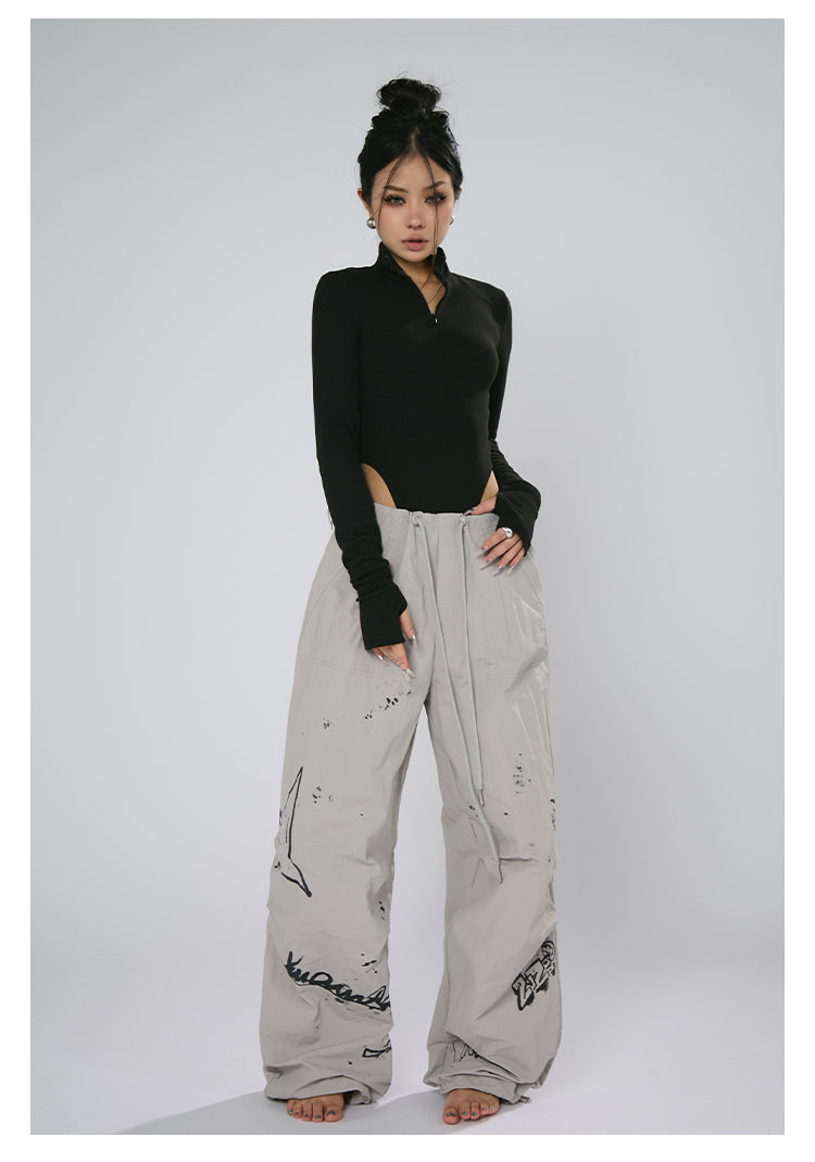 AN JITT's graffiti print work pants for women in spring and summer feature a jazz-inspired new American style with loose black dance pants.